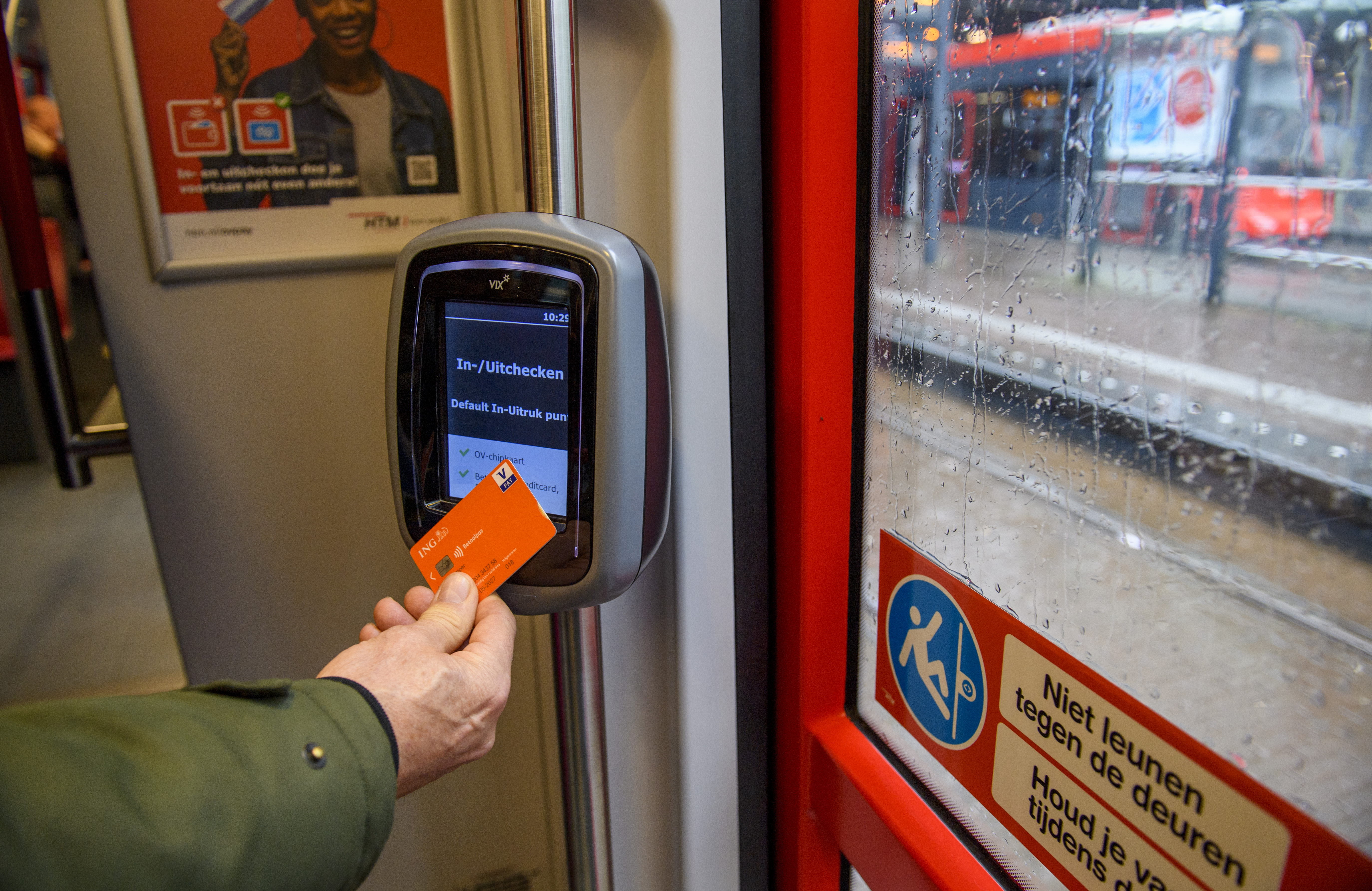 HTM reiziger checkt uit met OVpay via zijn bankpas in een HTM tram