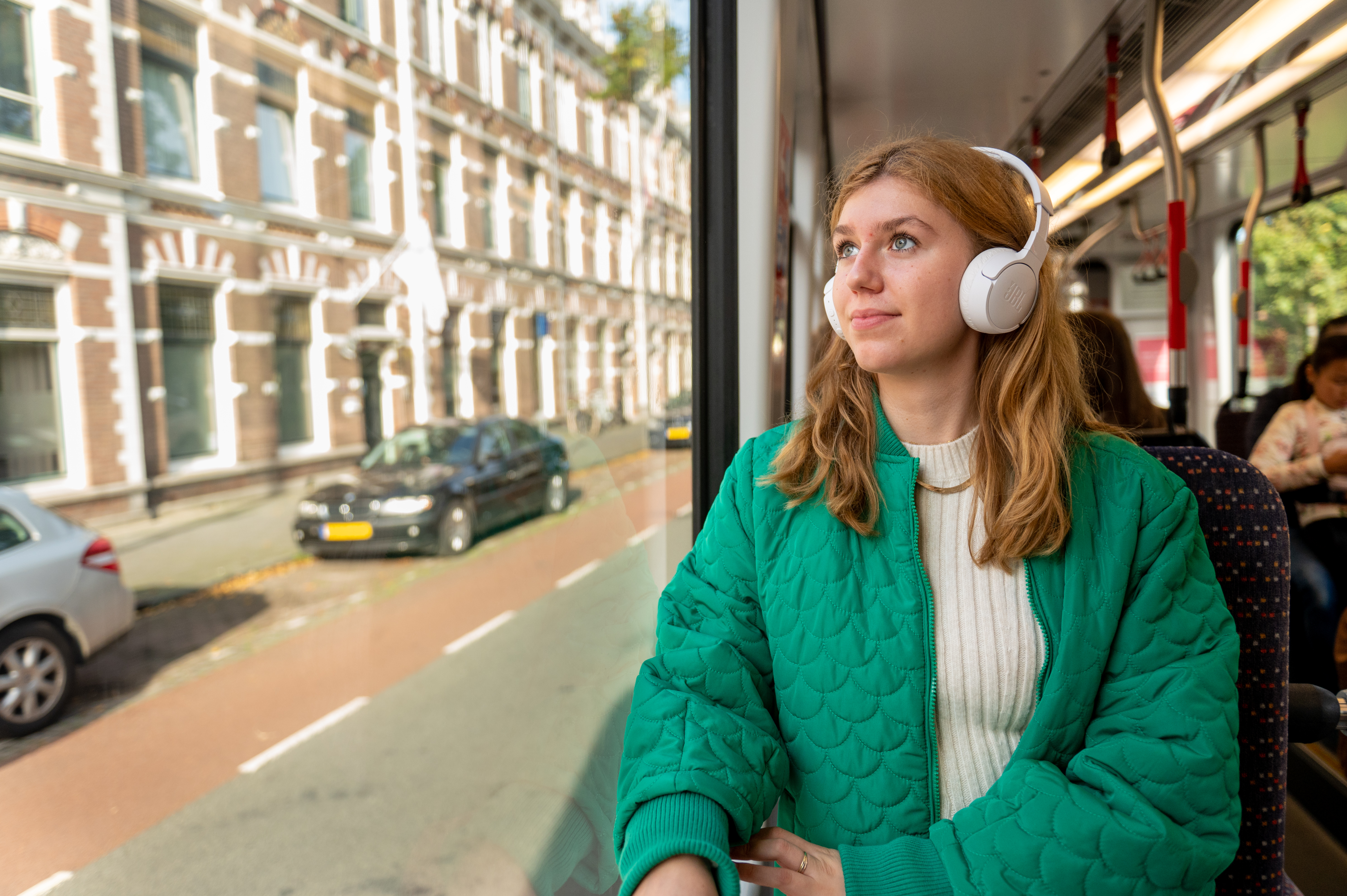 Vrouw zit in HTM tram en luister muziek met koptelefoon op