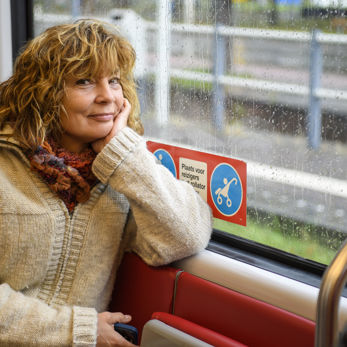 Vrouw zit in tram Vrouw zit in HTM tram en kijkt naar de camera