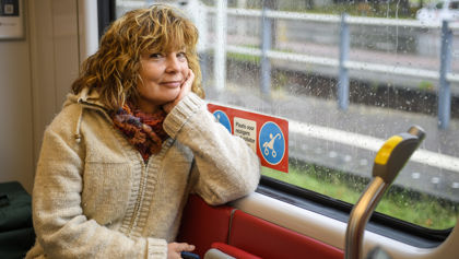 Vrouw zit in tram Vrouw zit in HTM tram en kijkt naar de camera