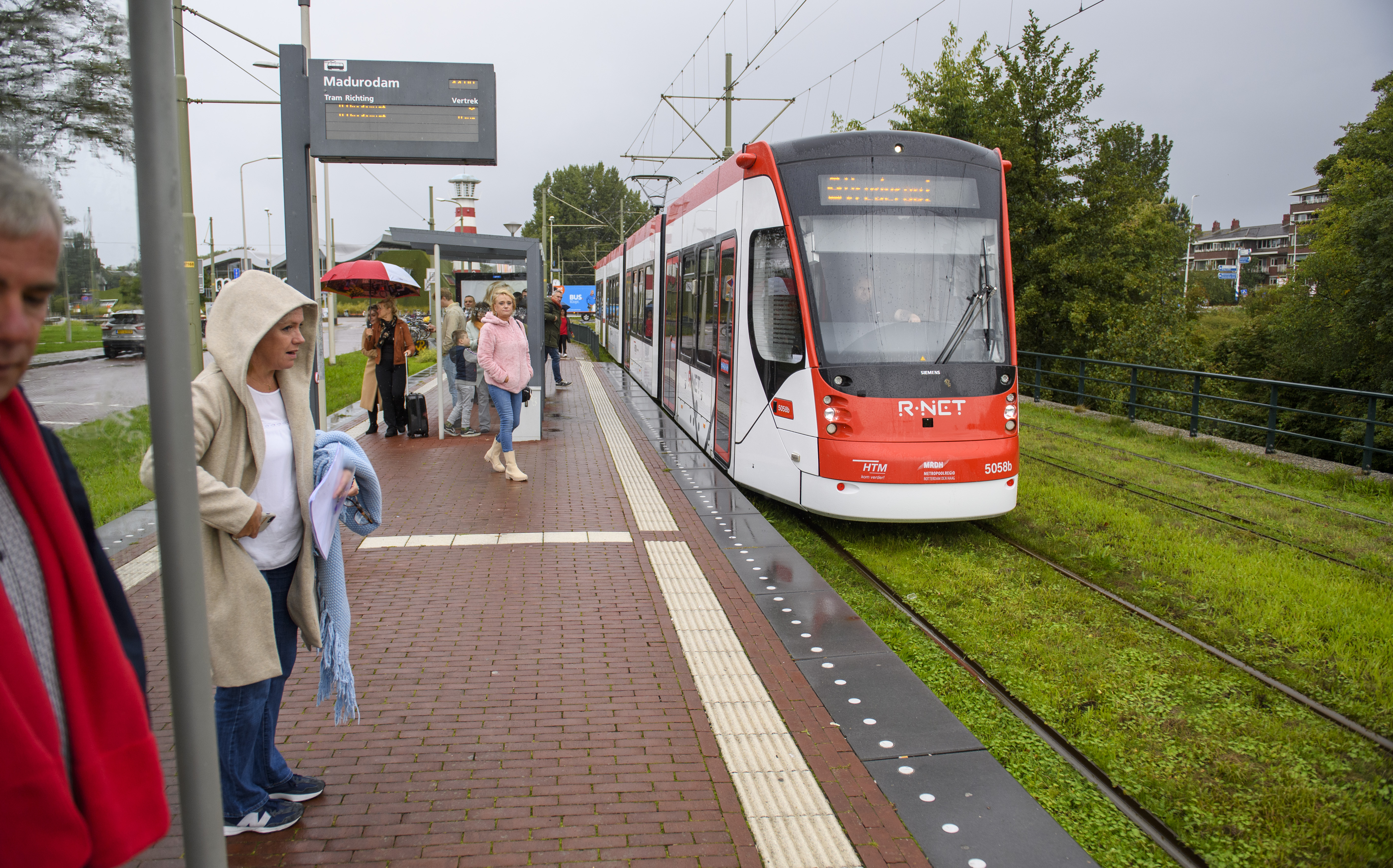 Reizigers op halte wachten op HTM tram