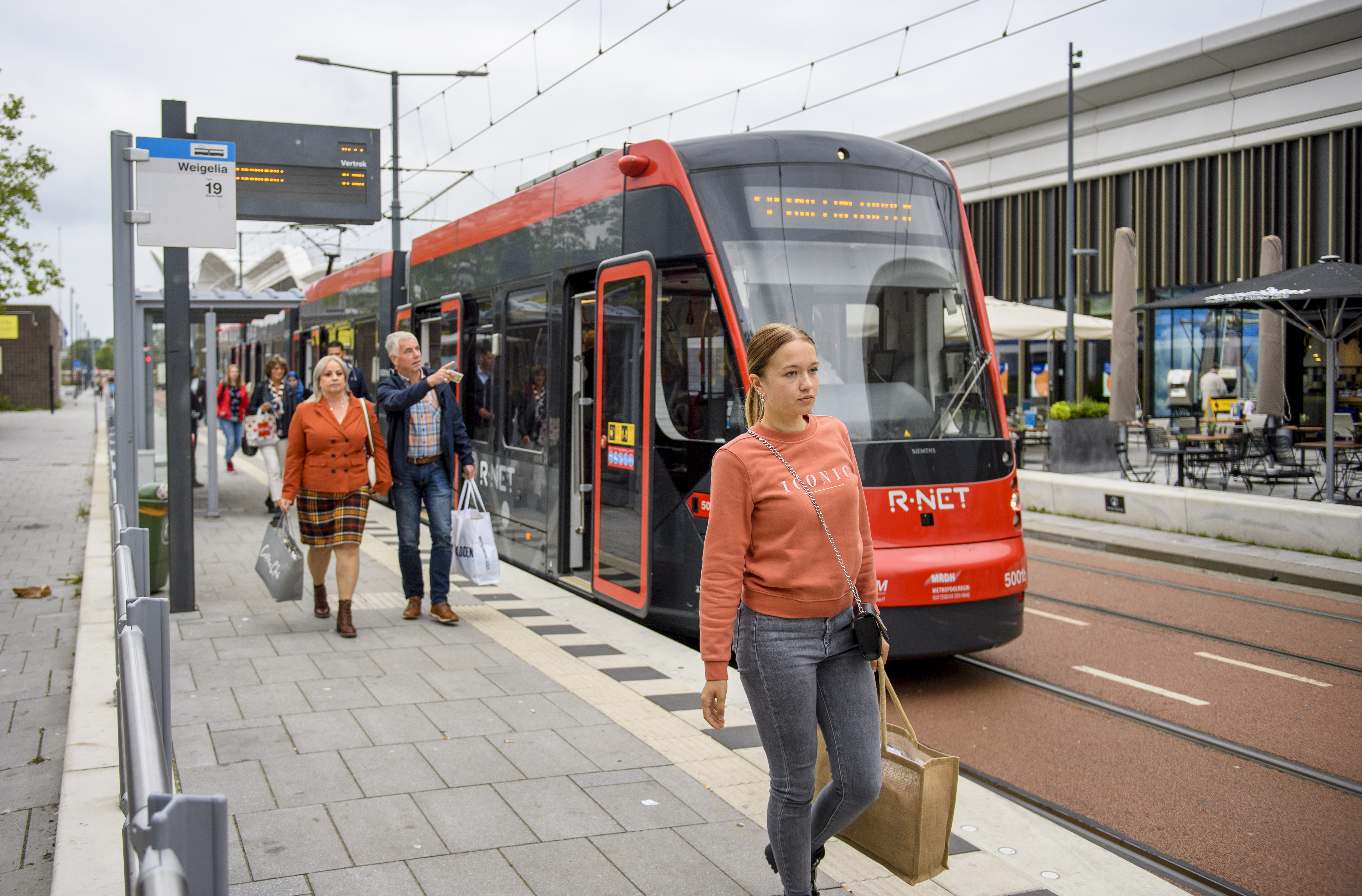 Reizigers lopen naast HTM tram bij de Mall Of The Netherlands