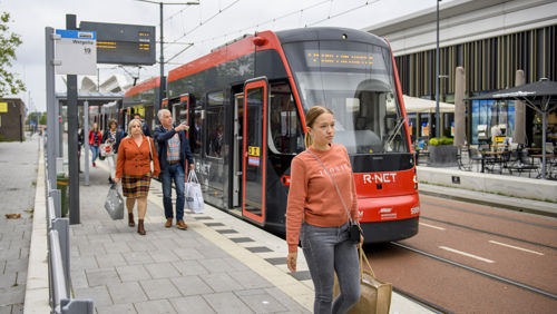 Reizigers bij de Mall Of The Netherlands Reizigers lopen naast HTM tram bij de Mall Of The Netherlands