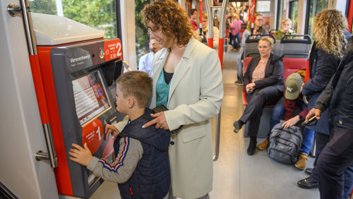 Moeder en kind kopen een tramkaartje Moeder en kind kopen tramkaartje bij kaartverkoopautomaat in HTM tram