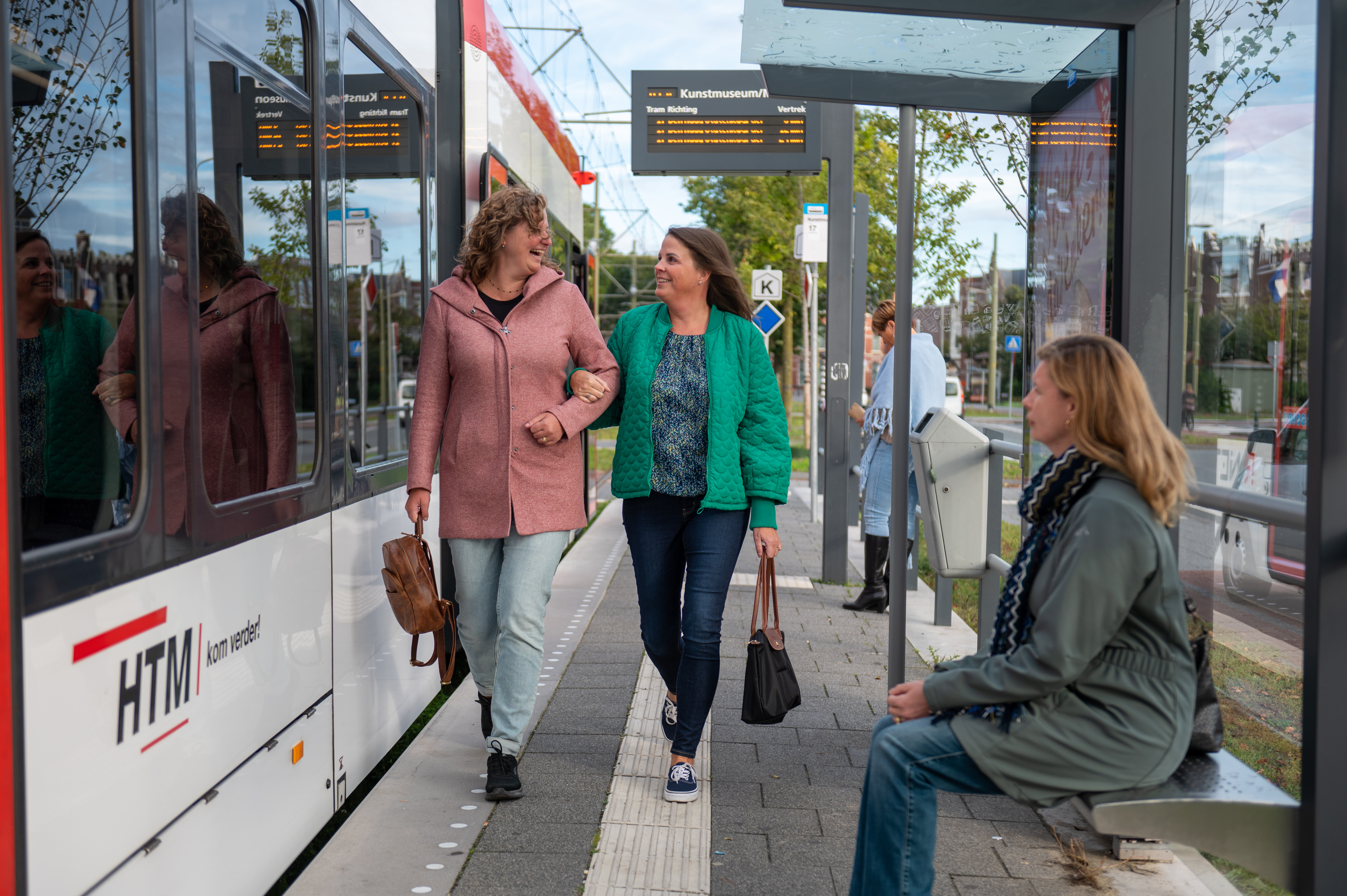 Reizigers lopen op halte naast HTM tram