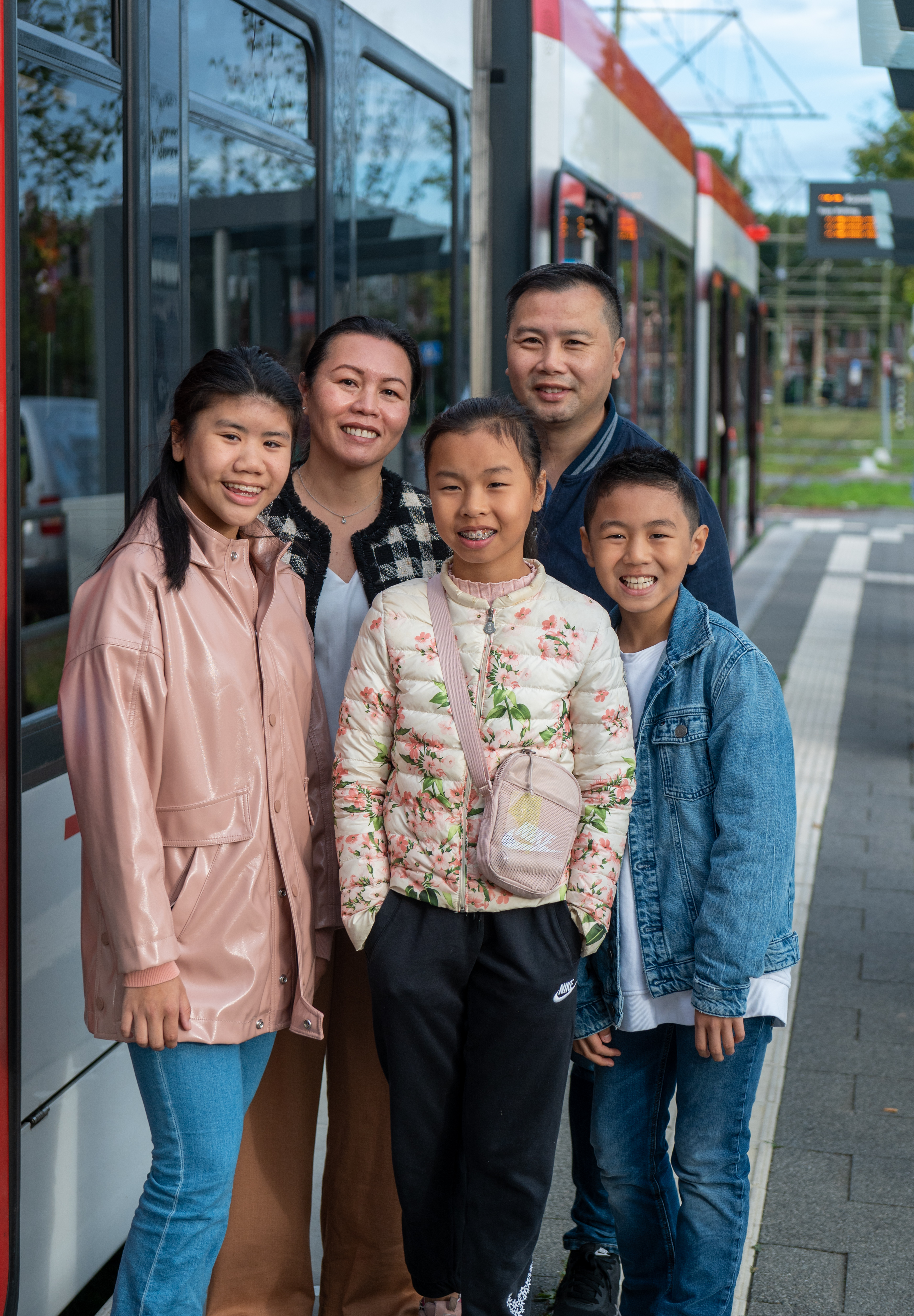 Gezin naast HTM tram lacht naar de camera