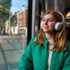 Vrouw zit in HTM tram en luister muziek met koptelefoon op Vrouw zit in HTM tram en luister muziek met koptelefoon op