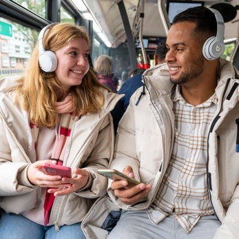 Man en vrouw luisteren samen muziek in HTM bus Man en vrouw luisteren samen muziek in HTM bus