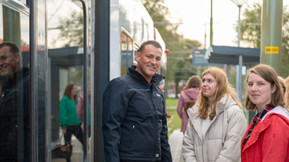 OV steward met twee reizigers naast tram HTM controleur met 2 reizigers naast HTM tram