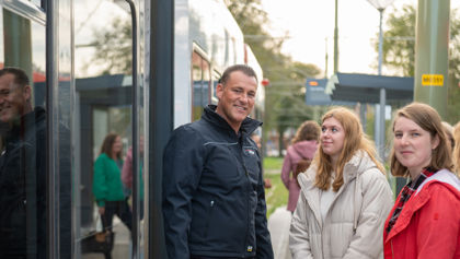 OV steward met twee reizigers naast tram HTM controleur met 2 reizigers naast HTM tram