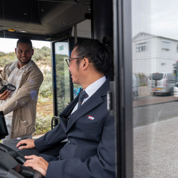 Buschauffeur verwelkomt reiziger Buschauffeur verwelkomt reiziger