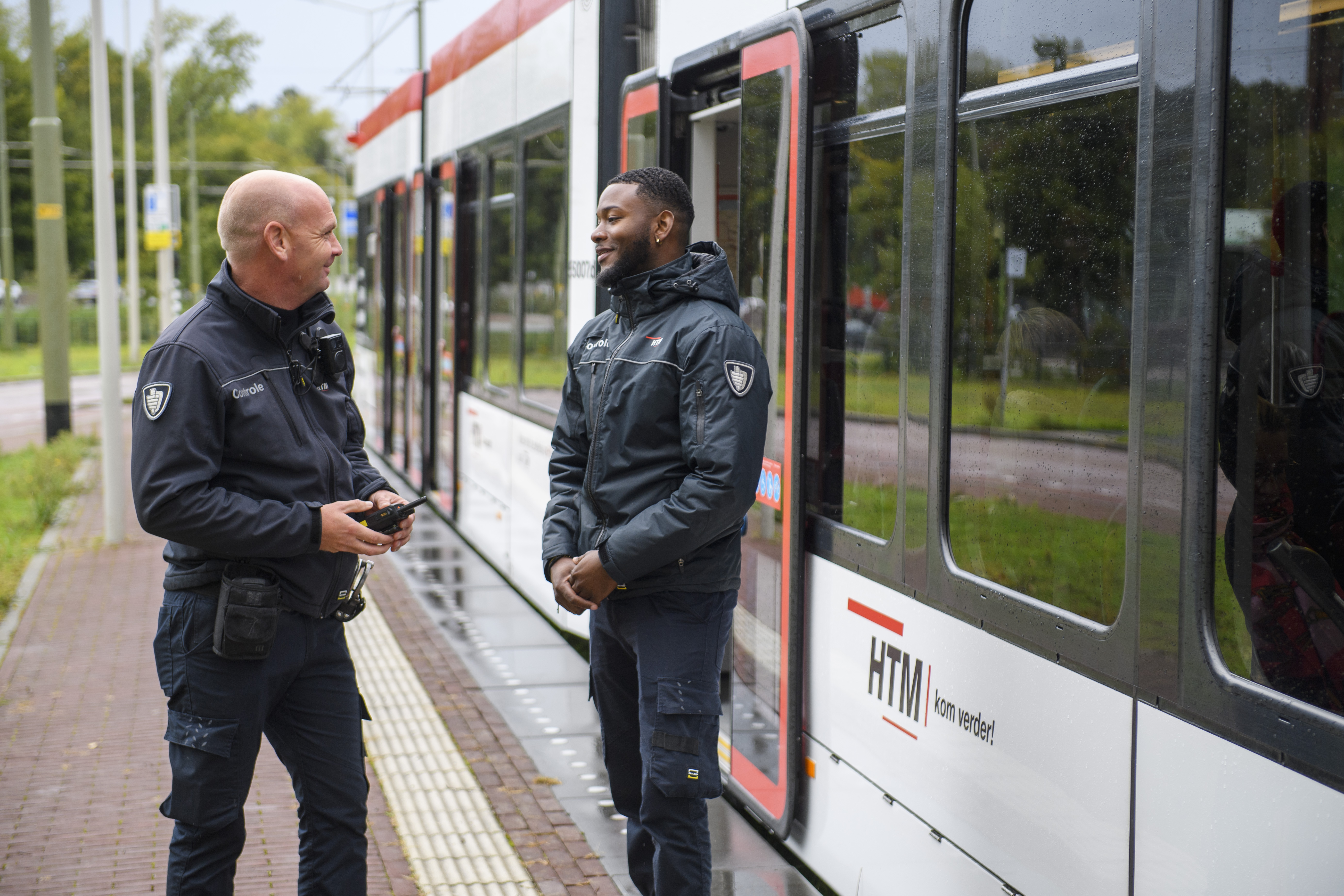 HTM BOA controleurs praten naast HTM tram