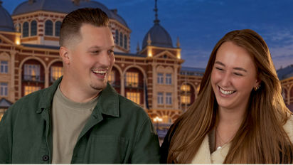 Man en vrouw lopen hand in hand voor het kurhaus Man en vrouw lopen hand in hand voor het kurhaus