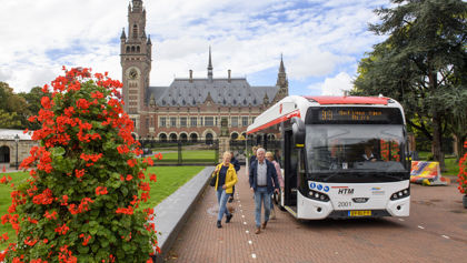 Reizigers stappen in HTM bus bij het Vredespaleis Reizigers stappen in HTM bus bij het Vredespaleis