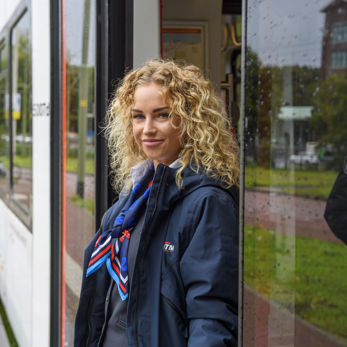 BOA staat in deuropening tram HTM boa staat in deuropening HTM tram en lacht naar de camera