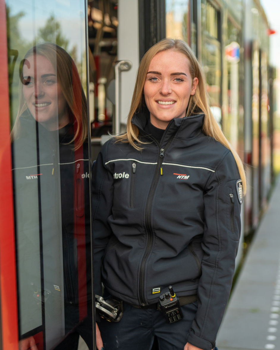BOA controleur staat in deuropening HTM tram BOA controleur staat in deuropening HTM tram en lacht naar de camera