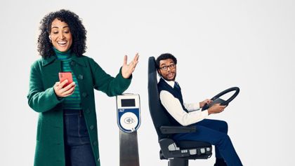 Vrouw met telefoon in haar hand is blij dat ze kan reizen met OVpay Vrouw met telefoon in haar hand is blij dat ze kan reizen met OVpay