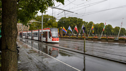 Wit met rode tram rijdt langs hofvijver Wit met rode HTM tram rijdt bij Hofvijver Den Haag