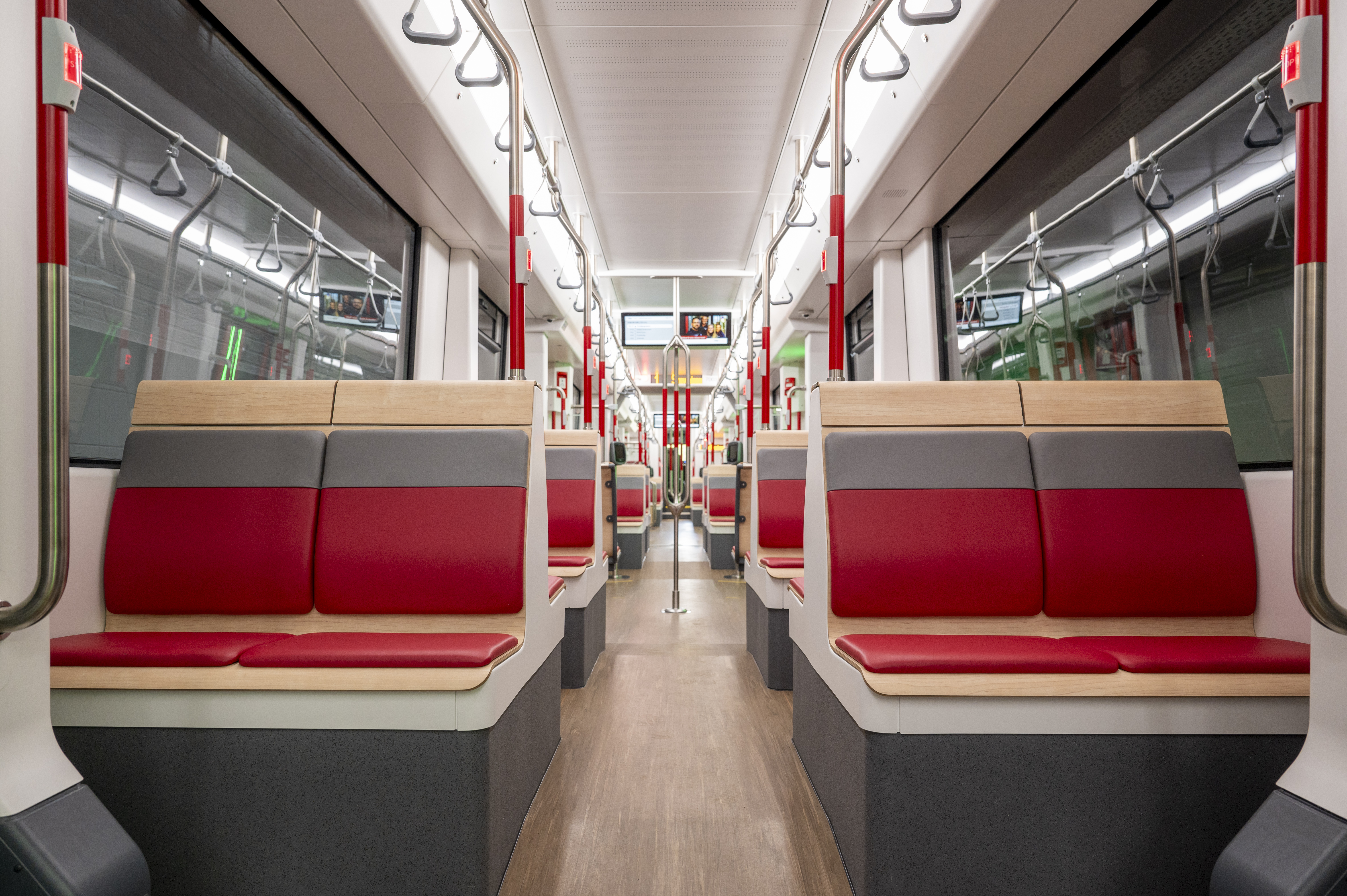 In de TINA zitten stoelen met rode bekleding en een licht houten afwerking