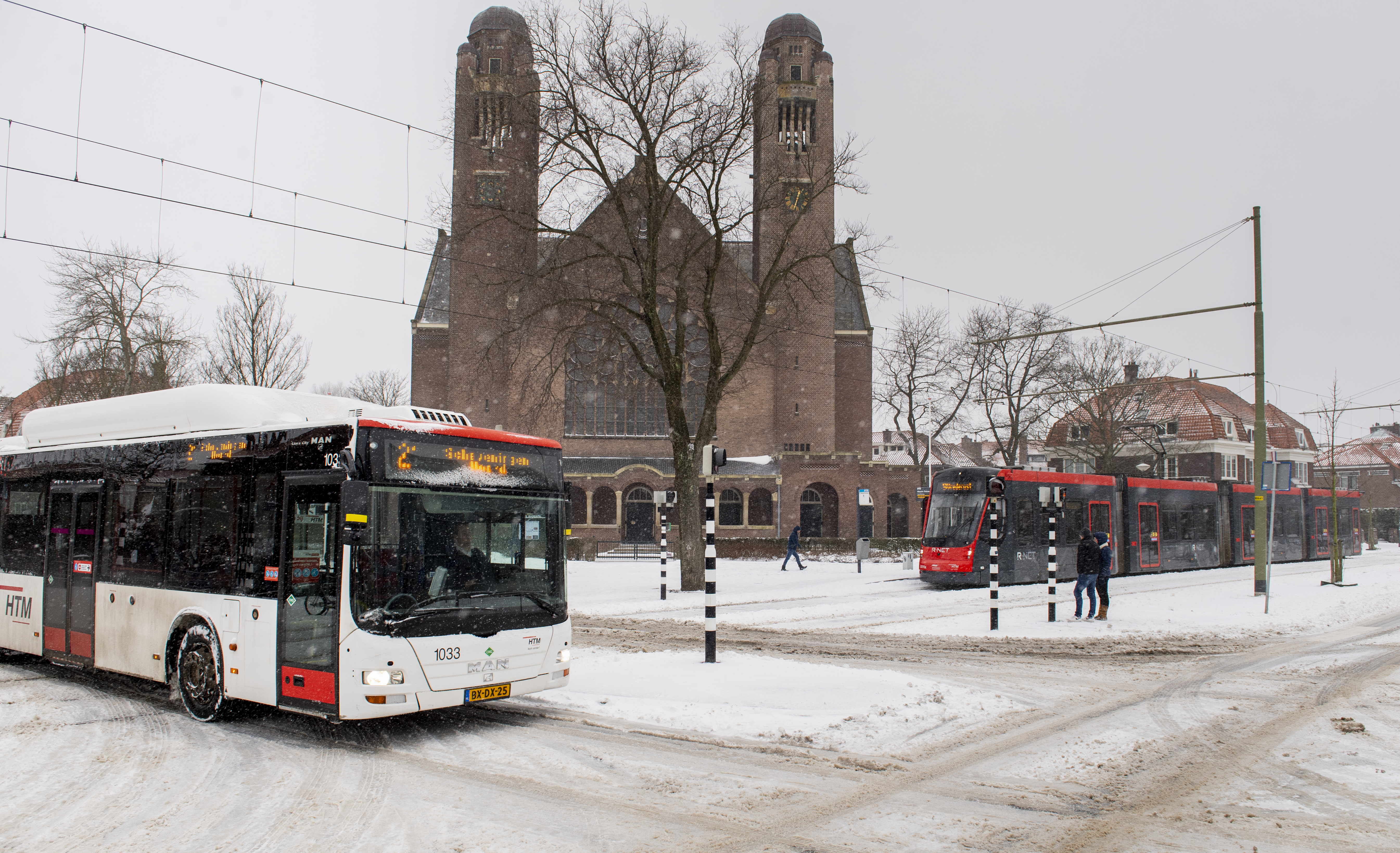 HTM bus en tram kruisen elkaar in de sneeuw