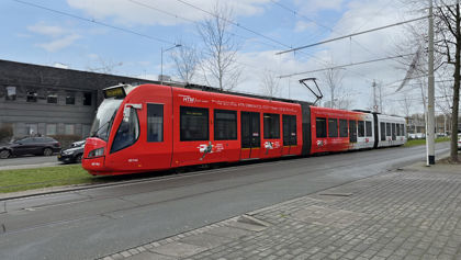 Rood met witte tram rijdt door de straat in Den Haag. In deze tram worden tests uitgevoerd. HTM Innovatietram rijdt door de straat
