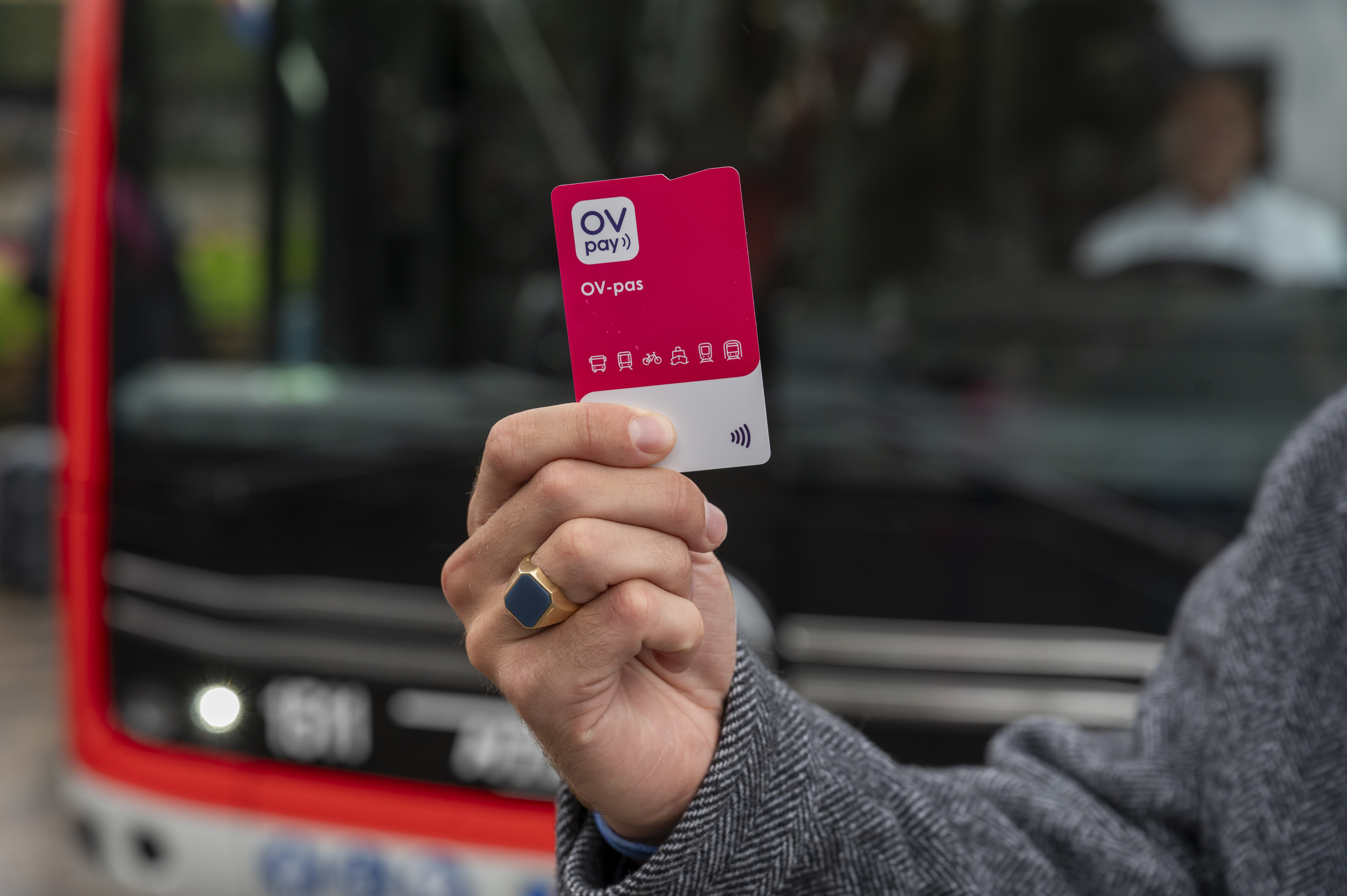 Mannenhand met OV-pas in zijn hand