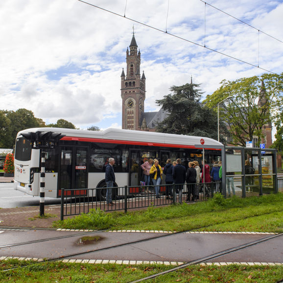 Reizigers stappen in bus bij het Vredespaleis Reizigers stappen in HTM bus bij het Vredespaleis