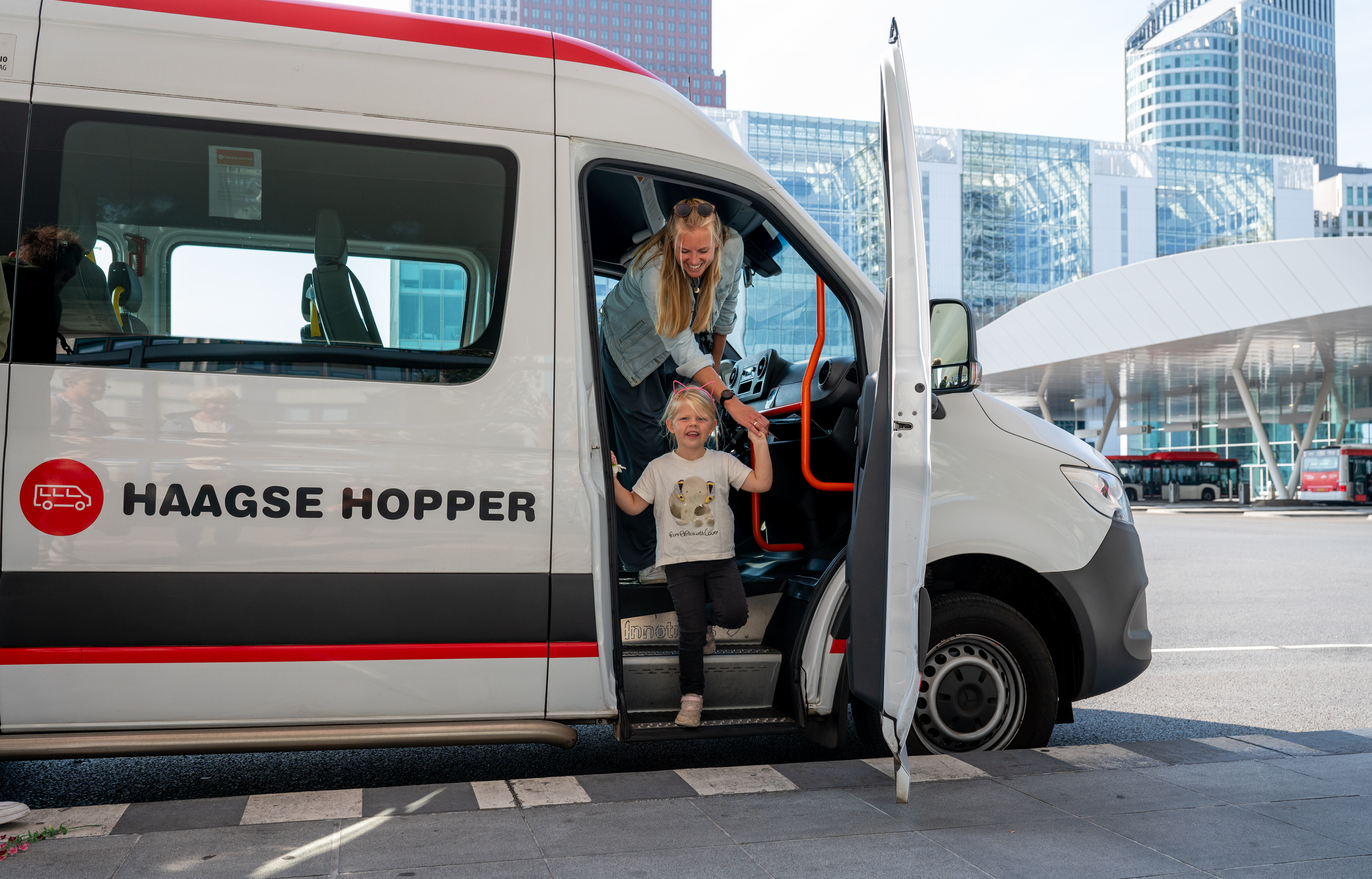Foto van vrouw en kind die uit de Haagse Hopper stappen