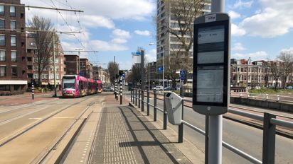 Digitaal haltedisplay op tramhalte met randstadrail op achtergrond Digitaal haltedisplay op tramhalte met randstadrail op achtergrond