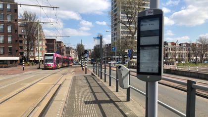 Digitaal haltedisplay op tramhalte met randstadrail op achtergrond Digitaal haltedisplay op tramhalte met randstadrail op achtergrond