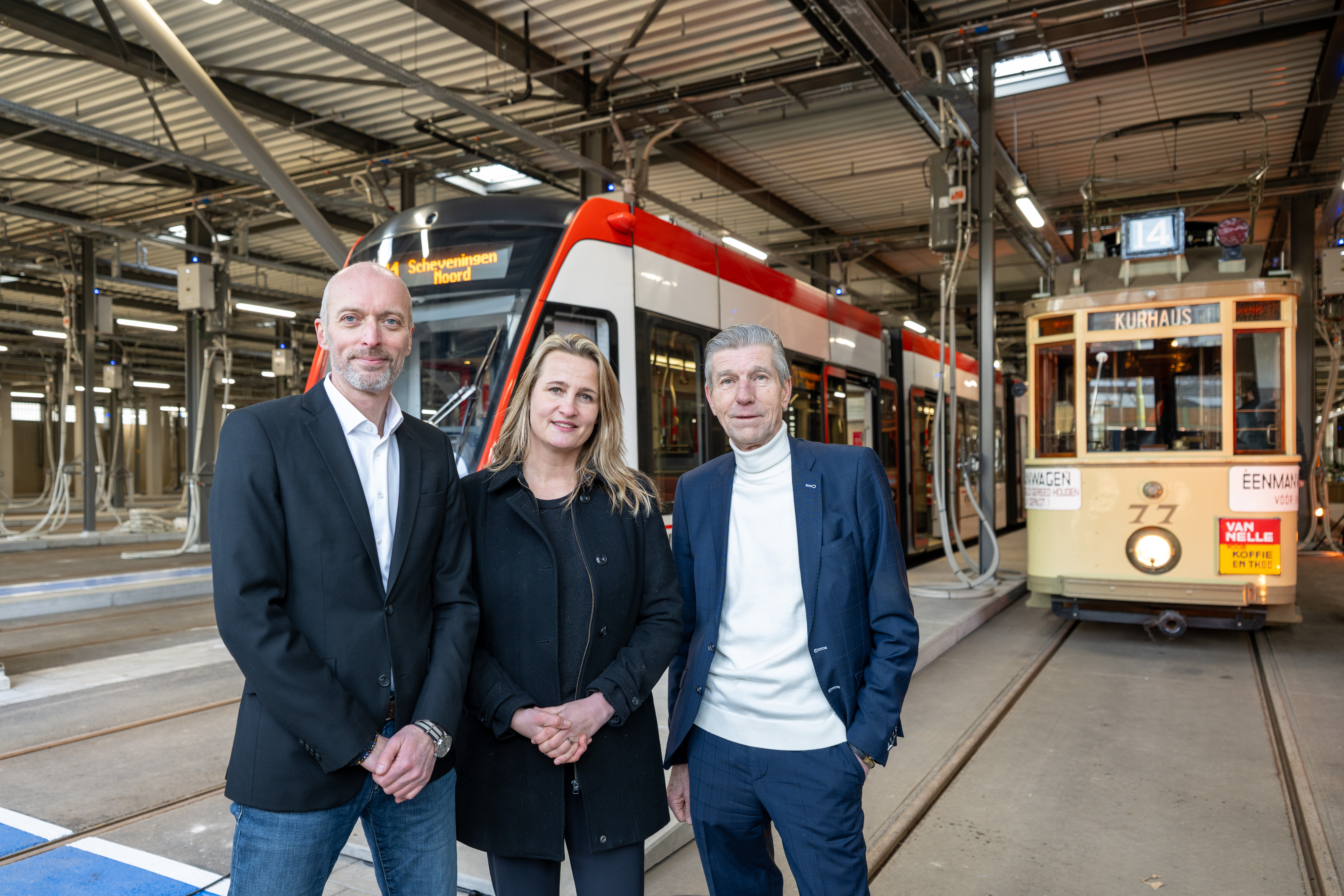 Rien Heilbron, Karen Bosch (operationeel directeur) en Simon Fortuyn voor een Avenio-tram en een historische tram in de remise