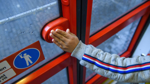 Kind drukt op knop van tramdeur Reiziger drukt op knop van de tramdeur in HTM tram