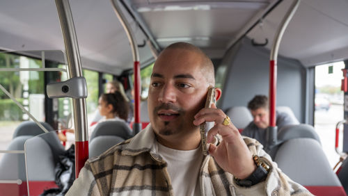 Reiziger met mobiel in HTM Bus Reiziger met mobiel in HTM Bus