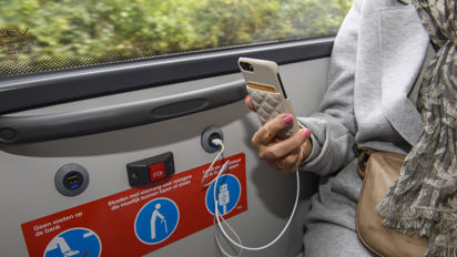 Reiziger laadt telefoon op in bus HTM reiziger laadt telefoon op in HTM bus