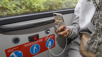 Reiziger laadt telefoon op in bus HTM reiziger laadt telefoon op in HTM bus