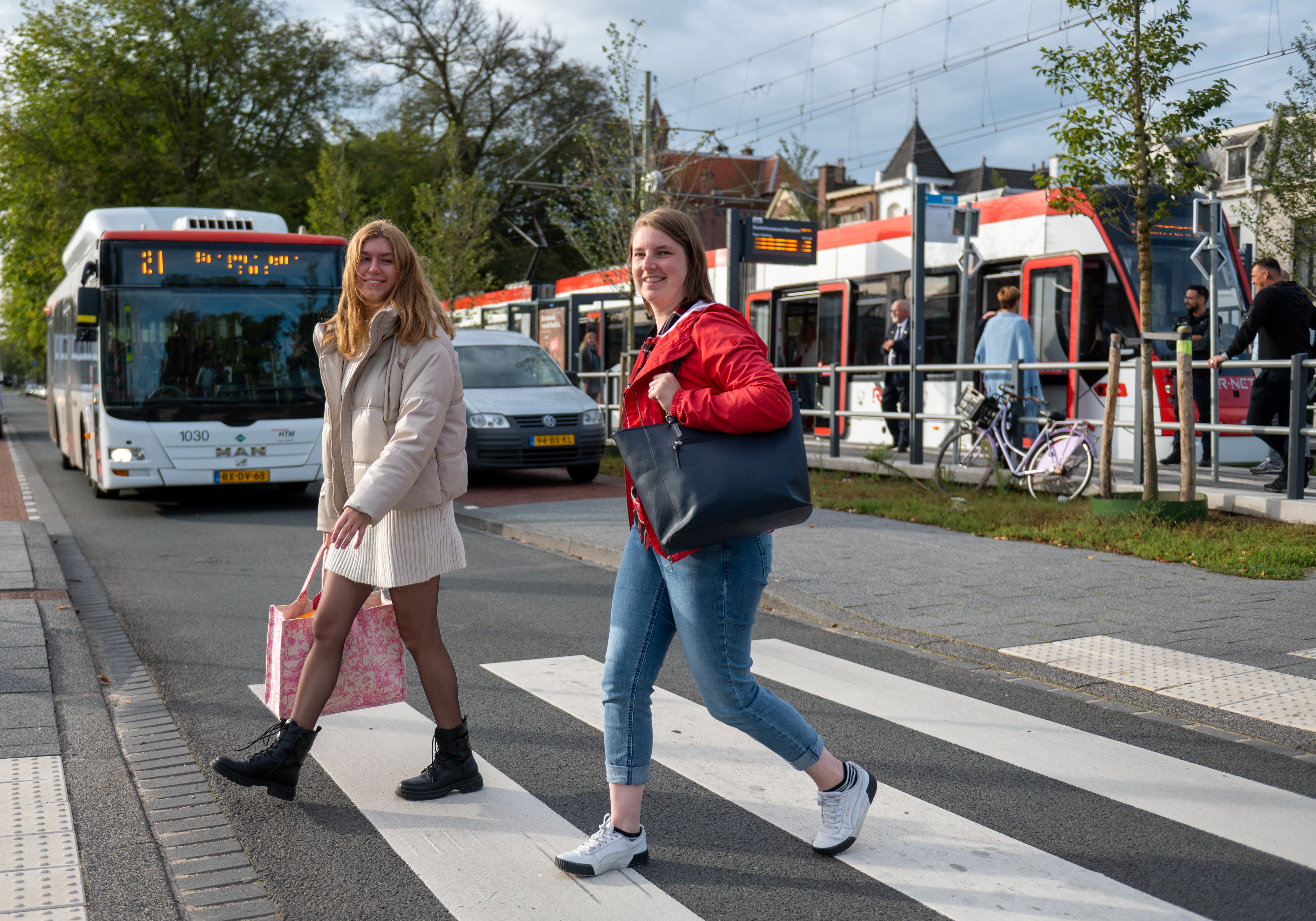Reizigers steken de straat over naast HTM tramhalte