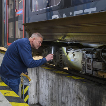Werkzaamheden aan tram door een monteur in de werkplaats Werkzaamheden aan HTM tram