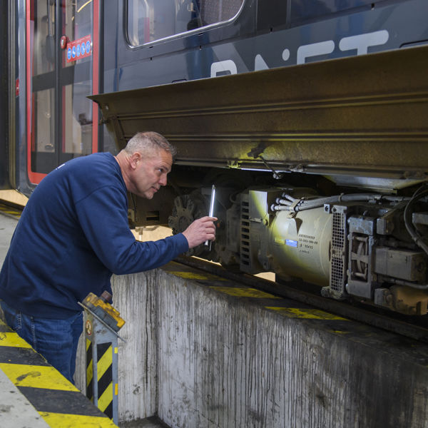 Werkzaamheden aan tram door een monteur in de werkplaats Werkzaamheden aan HTM tram
