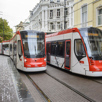 Twee trams rijden langs elkaar Twee HTM trams langs naast elkaar langs winkels in Den Haag