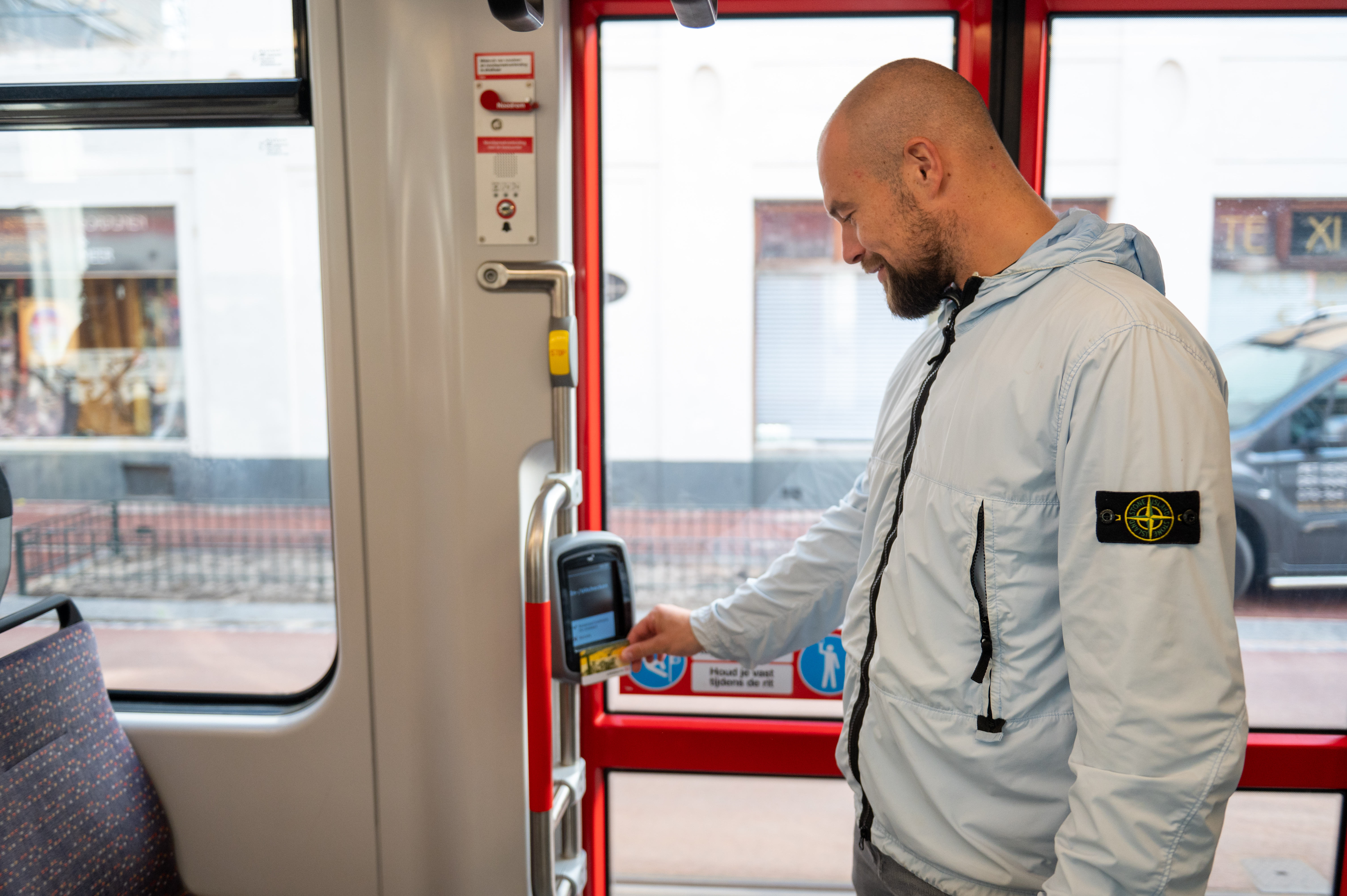 Reiziger checkt in met OV-chipkaart in HTM tram