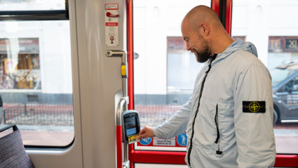 Man checkt in met OV-chipkaart Reiziger checkt in met OV-chipkaart in HTM tram