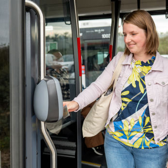 Vrouw checkt uit in tram Reiziger checkt uit in HTM tram