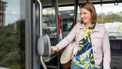 Vrouw checkt uit in tram Reiziger checkt uit in HTM tram