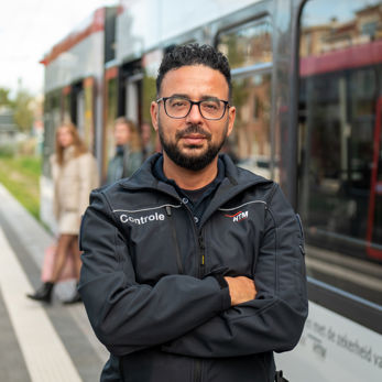 BOA controleur staat naast HTM tram BOA controleur staat naast HTM tram en kijkt in de camera