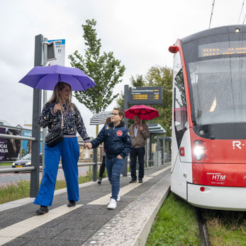 Moeder en zoon lopen in de regen op een tramhalte Moeder en zoon lopen in de regen op een tramhalte