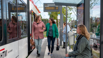 Reizigers lopen op tramhalte HTM reizigers lopen op tramhalte naast HTM tram
