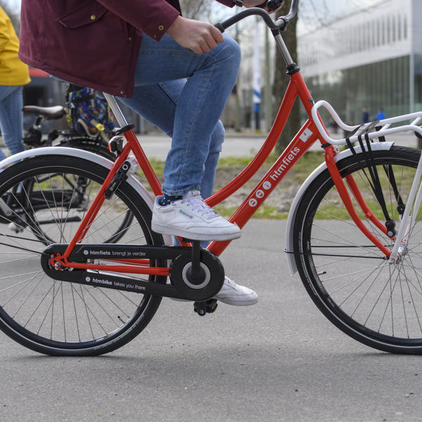Reiziger rijdt op HTM fiets Reiziger rijdt op HTM fiets
