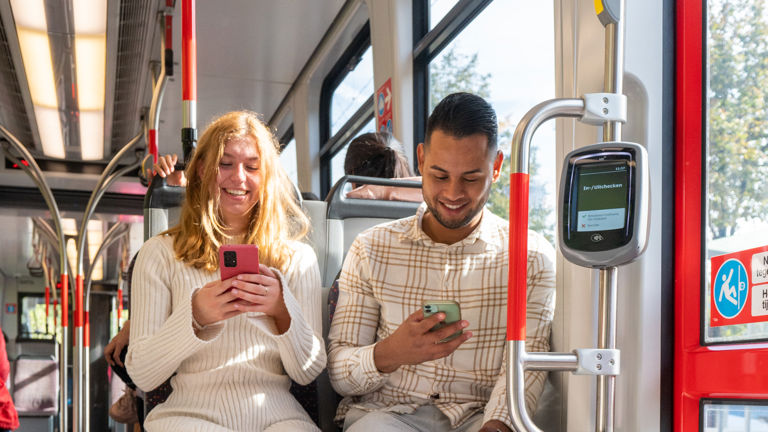Reizigers in HTM tram Reizigers gebruiken telefoon in HTM tram