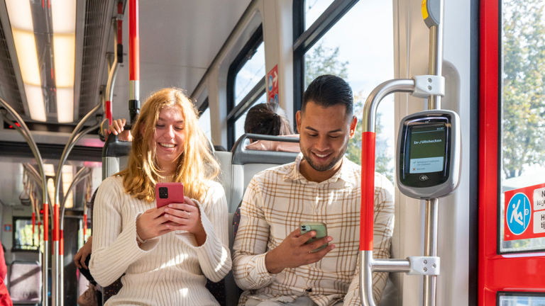 Reizigers in HTM tram Reizigers gebruiken telefoon in HTM tram