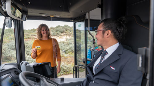 Buschauffeur zit achter het stuur van HTM bus Buschauffeur zit achter het stuur van HTM bus en groet reiziger